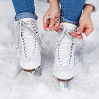 person tying white skates